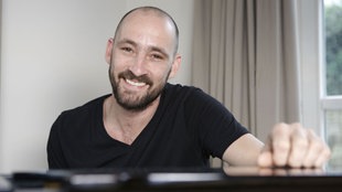 Gentleman sitzt an seinem Klavier
