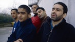 Asian Dub Foundation stehen an einer Wand