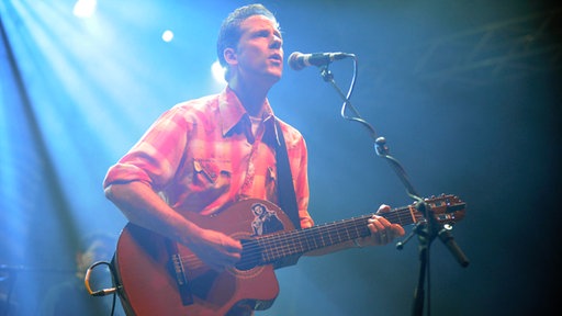 Calexico Sänger mit Gitarre auf der Bühne