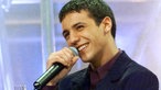 Faudel lächelt mit Mikrophon in der Hand