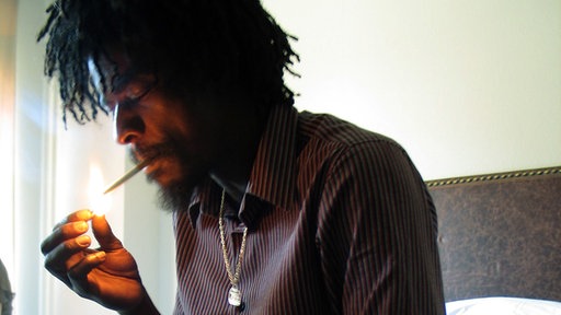 Seu Jorge zündet sich eine Zigarette an