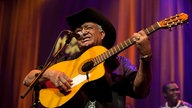 Eliades Ochoa spielt seine Gitarre auf der Bühne