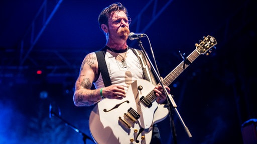 Frontmann der Band auf der Bühne mit Gitarre