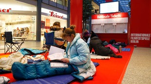 Eine Frau im Schlafsack vor dem Berlinale-Ticketschalter