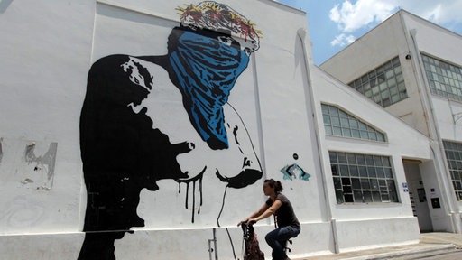 Junge Frau vor Graffiti Aphrodite Athen