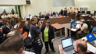Die Anwälte der Angeklagten Zschäpe, Anja Sturm (l-r), Wolfgang Heer und Wolfgang Stahl, sitzen am 28.07.2015 im Gerichtssaal in München (Bayern) an ihrem Platz, während die Angeklagte Beate Zschäpe neben ihrem vierten Anwalt Mathias Grasel (r) steht