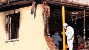 Beamte der Spurensicherung durchsuchen am Montag (14.11.2011) ein durch eine Explosion zerstörtes Haus in Zwickau