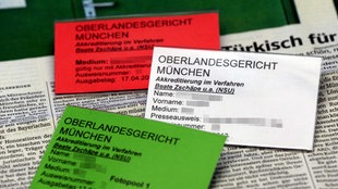 ILLUSTRATION - Drei Akkreditierungsausweise von Journalisten zum NSU-Prozess liegen in München (Bayern) auf einem Zeitungsartikel