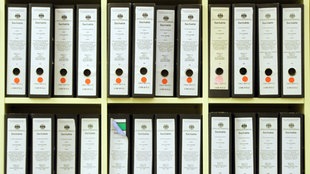 Prozessakten stehen im Gerichtssaal in München (Bayern) im Regal