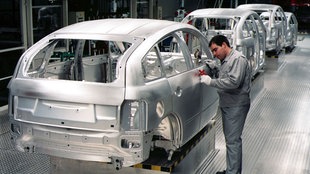 Ein Mann arbeitet an einem Auto in der Audi-Produktion 