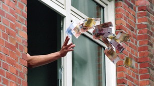 Weggeschimissenes Geld aus einem Fenster 