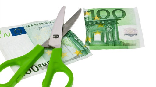 Geschnittener Geldschein mit Schere