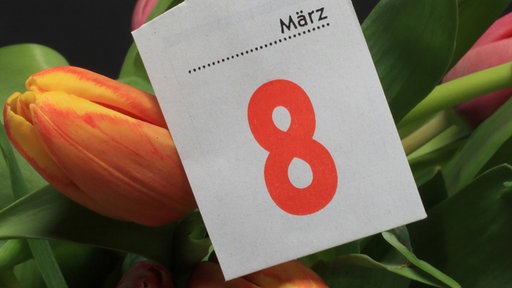 Međunarodni dan žena - 8. mart piše na kalendarskom listu koji stoji na "snopu" tulipana