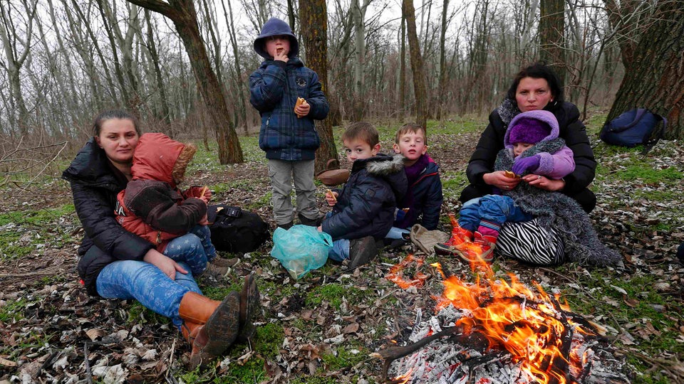 Albanska porodica se greje uz vatru nakon ilegalnog prelaska granice Srbije sa Mađarskom
