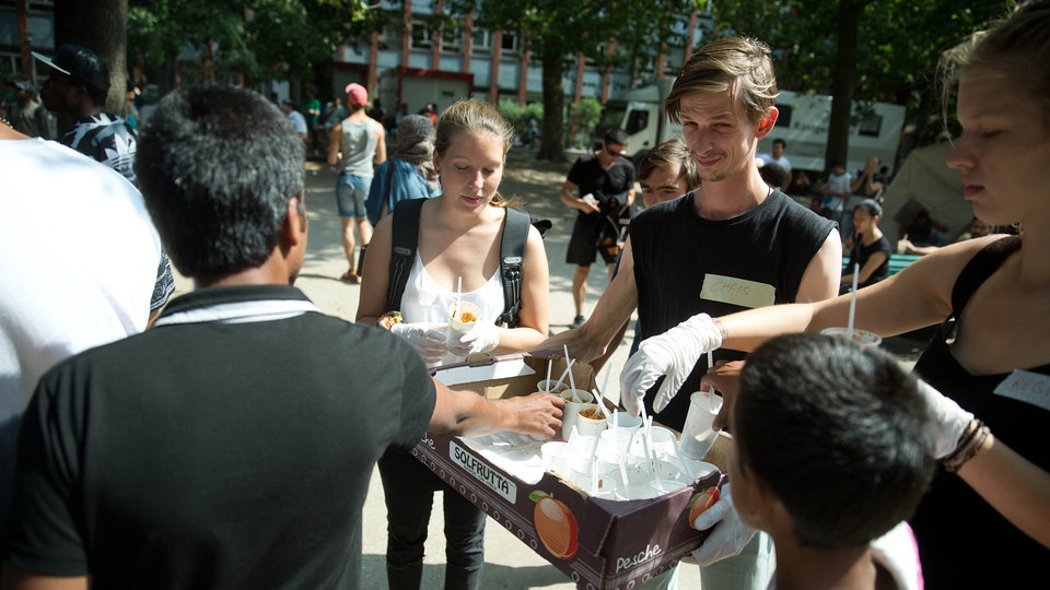 Ehrenamtliche der Initiative "Moabit hilft" versorgen Flüchtlinge mit Essen auf dem Gelände des Landesamts für Gesundheit und Soziales (LaGeSo) in Berlin