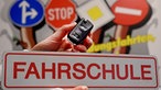 Fahrschul-Schriftzug und Verkehrsschilder
