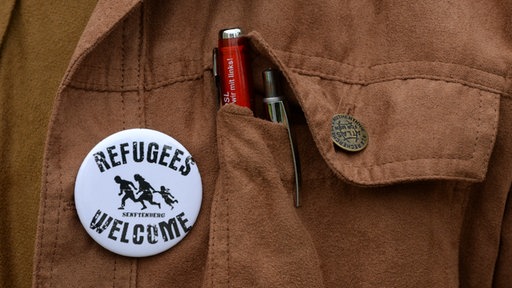 Sticker mit Aufschrift "Refugees Welcome" an einer Jacke